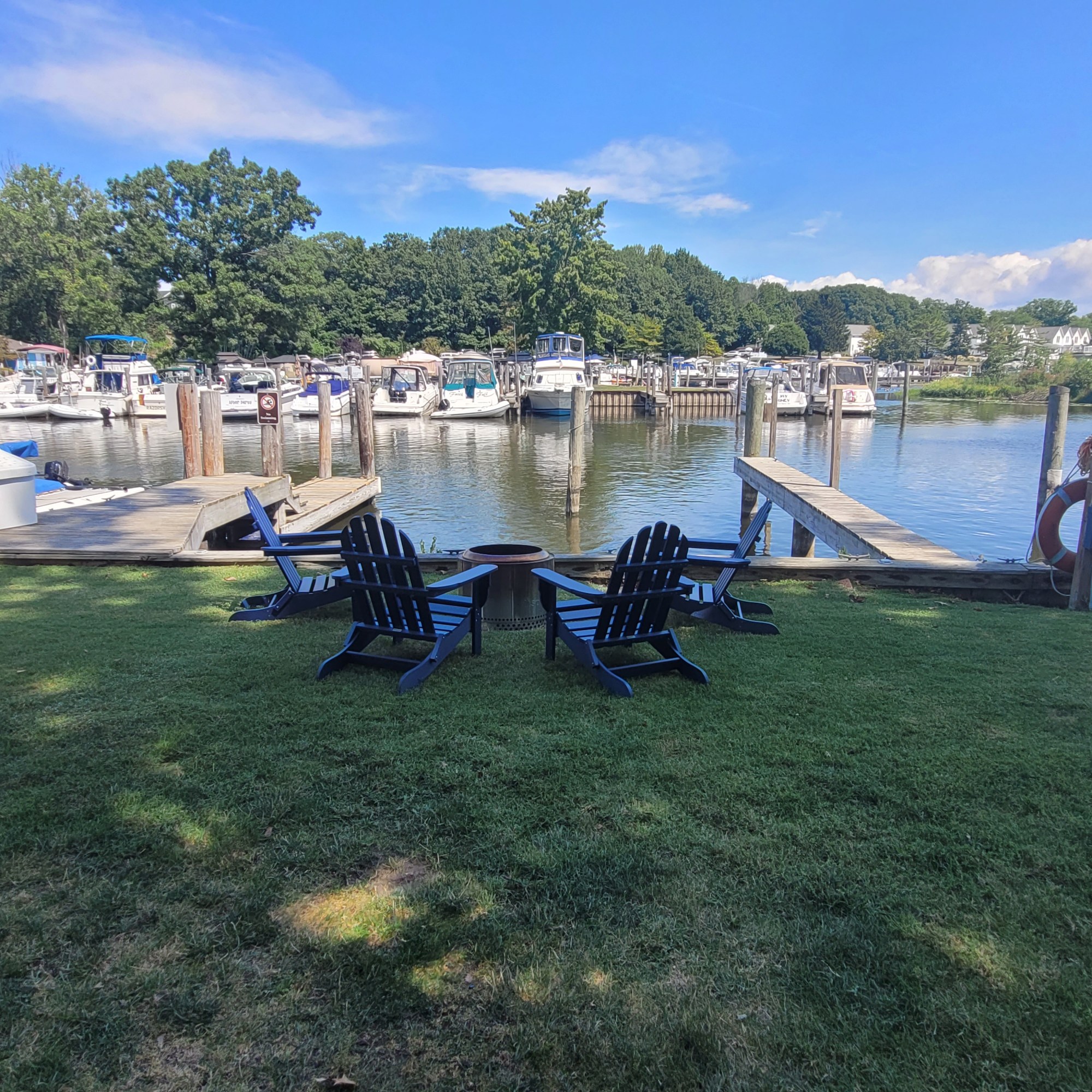 4 chairs sit around a fire pit next to the Black River